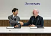Zwei Männer geben sich vor einem Renesas-Logo bei Vertragsunterlagen die Hand