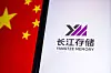 Smartphone mit YMTC-Logo neben unscharfer chinesischer Flagge