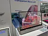 Transparentes Micro-LED-Display mit farbiger Animation auf einem Messestand