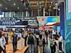 Volle Messehalle mit Besuchern an Technologieständen, unter anderem Arrow.