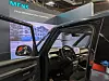Offenes Fahrzeugcockpit mit großem Display vor Siemens-PAVE360-Messestand.