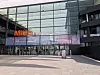 Verglaster Eingang Mitte einer Messehalle mit Banner der Messe Düsseldorf
