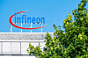 Infineon-Logo auf einem Gebäudedach in Frankfurt, teilweise von Bäumen verdeckt.