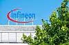 Infineon-Logo auf einem Gebäudedach in Frankfurt, teilweise von Bäumen verdeckt.