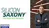Frank Bösenberg im Anzug vor Neonstreifen neben dem Silicon-Saxony-Logo