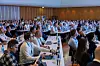 Voll besetzter Konferenzsaal beim Bordnetzkongress 2026 in Ludwigsburg mit Fachpublikum aus der Automobilindustrie, Teilnehmenden mit Headsets, Laptops, Namensschildern und Getränken an langen Tischen; internationale Fachkonferenz zu Bordnetz, Leitungssatzfertigung, Wire Harness, Automatisierung, Standardisierung, digitalem Zwilling, Software-defined Vehicle und nachhaltiger Fahrzeugproduktion