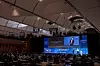Große Kongressbühne der 14. Internationalen Fachkonferenz „Bordnetze im Automobil“ 2026 im Reithaus Ludwigsburg mit Vortragendem auf der Bühne, blauem Bühnenhintergrund, großem Präsentationsscreen, voll besetztem Saal, Sponsorenlogos und Fahrzeug-Bordnetz-Grafik; Fachkonferenz zu Bordnetz, Leitungssatz, Kabelbaum, Wire Harness, EDS, Automatisierung, Digitalisierung, Standardisierung und Software-defined Vehicle
