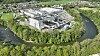 Luftbild einer Industrieanlage in Leoben-Hinterberg, Österreich, am Fluss und von Grünflächen umgeben.