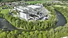 Luftbild einer Industrieanlage in Leoben-Hinterberg, Österreich, am Fluss und von Grünflächen umgeben.
