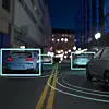 Mehrere Autos auf einer nächtlichen Straße mit digitalen Markierungen und Fahrspurlinien.