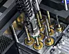 Nahaufnahme einer automatisierten Maschine mit Metallfedern und Messinganschlüssen in einer Werkstatt.