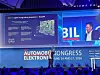 Lars Reger von NXP Semiconductors hält auf der Bühne des 30. AUTOMOBIL-ELEKTRONIK Kongresses 2026 in Ludwigsburg ein Hardware-Board in die Höhe und präsentiert vor großem Publikum eine Folie zum S32N7 Super-Integration Processor und Ara240 für Artificial Intelligence Defined Vehicles. Auf der Leinwand sind ein NXP-Entwicklungsboard, technische Stichpunkte zu Echtzeitdaten, KI, Safety, Security, Low-Power-Betrieb und Fahrzeugdaten-Orchestrierung sowie das Kongressbranding mit 30 Jahre AEK, AUTOMOBIL-ELEKTRONIK Kongress, 16. und 17. Juni 2026 zu sehen.