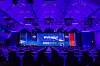 Großer Konferenzsaal des 30. AUTOMOBIL-ELEKTRONIK KONGRESSES 2026 in Ludwigsburg vor Beginn des Programms mit leer bestuhlten Tischreihen, Wasserflaschen, Gläsern und Notizplätzen. Die Bühne ist in kräftiges blau-violettes Licht getaucht und zeigt einen großen zentralen Bildschirm mit der Aufschrift „Welcome!“. Links und rechts sind AEK-Logos, Kongressgrafiken, rote Bühnensessel und das Branding des 30. AUTOMOBIL-ELEKTRONIK KONGRESSES mit dem Datum 16. und 17. Juni 2026 zu sehen. Die Decke des Saals ist mit Bögen, Lichttraversen und violetten LED-Akzenten gestaltet. Das Bild zeigt die professionelle Inszenierung einer großen Automotive-Fachkonferenz und eignet sich als Schmuckbild für Berichte über den 30. AUTOMOBIL-ELEKTRONIK KONGRESS, Veranstaltungseröffnung, Konferenzsaal, Bühne, AEK_live, Automotive Computing, Software-defined Vehicle, KI im Fahrzeug, Elektronikbranche, Fachkongress Ludwigsburg und Eventatmosphäre.