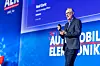 Ned Curic, Chief Engineering and Technology Officer bei Stellantis, steht auf der Bühne des 30. AUTOMOBIL-ELEKTRONIK Kongresses 2026 in Ludwigsburg und hält einen Vortrag über Software-defined Vehicles, STLA Brain, Smart Cockpit, zentrale Fahrzeugarchitekturen und die Rolle von Software im Auto. Er trägt einen dunklen Anzug, ein blaues Hemd und eine Brille, spricht mit Headset-Mikrofon und hält einen Presenter in der Hand. Im Hintergrund ist eine große blaue Bühne mit AEK-Branding, dem Jubiläumslogo zum 30. AUTOMOBIL-ELEKTRONIK Kongress und einer Präsentationsfolie mit seinem Namen zu sehen. Das Bild eignet sich für Beiträge über Stellantis, Ned Curic, Fahrzeugsoftware, Software-defined Vehicle, digitale Cockpits, Elektronikarchitekturen, KI im Fahrzeug, Smart Cockpit, STLA Brain, Kundenerlebnis im Auto, Automotive Engineering und den AUTOMOBIL-ELEKTRONIK Kongress in Ludwigsburg.