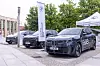 Ausgestellte Fahrzeuge vor dem Veranstaltungsort des 30. AUTOMOBIL-ELEKTRONIK Kongresses 2026 in Ludwigsburg. Im Vordergrund steht ein BMW iX3 mit Aufschrift „Der neue BMW iX3“, daneben weitere Fahrzeuge sowie eine BMW-Fahne und ein Zelt der BMW AG Niederlassung Stuttgart. Die Autos stehen auf dem Außengelände vor Bäumen und dem Kongressgebäude. Das Bild zeigt Fahrzeuge als zentrale Protagonisten eines Automobilkongresses und eignet sich für Beiträge über den AEK, den AUTOMOBIL-ELEKTRONIK Kongress, Fahrzeugausstellung, BMW, Elektromobilität, neue Fahrzeugmodelle, Automotive-Technologien, Software-defined Vehicles, E/E-Architekturen, KI im Auto, digitale Fahrzeugfunktionen und den Branchentreff in Ludwigsburg.