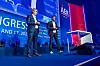 Dr. Thomas Irawan und Dr. Christian Salzmann stehen gemeinsam auf der Bühne des 30. AUTOMOBIL-ELEKTRONIK Kongresses 2026 in Ludwigsburg und halten einen Vortrag zum Eclipse-S-CORE-Projekt. Beide Speaker tragen Anzug beziehungsweise Sakko, halten Presenter in der Hand und stehen vor dem blauen Bühnenhintergrund mit AEK-Branding, Sponsorlogos und dem Hashtag AEK_live. Die Aufnahme zeigt eine Fachpräsentation zu Automotive Open Source, Software-defined Vehicles, S-CORE, Serienentwicklung, Safety, Security, Softwarekomplexität, E/E-Architekturen, Standardisierung und Zusammenarbeit zwischen OEMs, Zulieferern und Toolanbietern. Das Bild eignet sich für Beiträge über Dr. Thomas Irawan, Dr. Christian Salzmann, ETAS, BMW, Eclipse S-CORE, Open-Source-Software im Fahrzeug, Automotive Software, digitale Fahrzeugplattformen und den 30. AUTOMOBIL-ELEKTRONIK Kongress in Ludwigsburg.