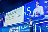 Alwin Bakkenes, Head of Software Engineering R&D bei Volvo Cars, steht auf der Bühne des 30. AUTOMOBIL-ELEKTRONIK Kongresses 2026 in Ludwigsburg und hält einen Vortrag mit dem Titel „Volvo Cars Reinvention for a Software-defined Future. And why it matters.“ Er trägt ein hellblaues Hemd, eine dunkle Hose, eine Brille und ein Headset-Mikrofon und hält einen Presenter in der Hand. Links auf der großen Präsentationsfolie steht „Three key challenges to resolve if you want to stay in business“ mit den Punkten „Electrification“, „End of globalisation“, „Hyper competition“ und „Unique opportunities for all three“. Rechts ist Alwin Bakkenes zusätzlich groß im Live-Kamerabild auf der Bühnenleinwand zu sehen. Im Hintergrund erscheinen das Branding des AUTOMOBIL-ELEKTRONIK Kongresses, das 30-Jahre-AEK-Logo, das Veranstaltungsdatum 16. und 17. Juni 2026 sowie Sponsorenlogos wie Microsoft, Qualcomm, Synopsys und Texas Instruments. Das Bild eignet sich für Beiträge über Alwin Bakkenes, Volvo Cars, Software-defined Vehicles, Software Engineering, zonale Fahrzeugarchitektur, zentrale Rechner im Auto, Over-the-Air-Updates, Software Factory, Vehicle Data, Sicherheitsentwicklung, KI in der Fahrzeugentwicklung, Google-Partnerschaft, Android Automotive, vernetzte Fahrzeuge, Elektrifizierung, Hyperwettbewerb, globale Fahrzeugentwicklung und den AUTOMOBIL-ELEKTRONIK Kongress in Ludwigsburg.