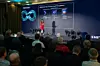 Karima Dridi, Vice President of Productivity Engineering bei Arm, vor einer großen Präsentationsleinwand mit sitzendem Publikum.