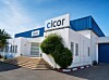 Außenansicht des Firmengebäudes von Cicor Digital Tunisie in Borj-Cedria in Tunesien mit weißer Fassade, blauem Hallendach, blauem Rolltor und zwei sichtbaren Cicor-Schildern am Gebäude. Der Standort wurde von Deltec-Eigner Carsten Ellermeier übernommen und erweitert den Deltec-Unternehmensverbund um zusätzliche Fertigungskapazitäten in den Bereichen Kabelkonfektion, Kunststoffspritzguss sowie Modul- und Produktherstellung. Das Bild zeigt den tunesischen Fertigungsstandort, der die internationale Aufstellung von Deltec im EMS-Umfeld ergänzt und die vertikale Integration entlang der Wertschöpfungskette unterstützt.