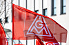Rote IG Metall Fahne vor einem Industriegebäude als Symbolbild für die Tarifrunde 2026 in der Metall und Elektroindustrie, die Kündigung der Entgelttarifverträge durch die IG Metall, bevorstehende Tarifverhandlungen für rund 3,8 Millionen Beschäftigte, Forderungen nach höheren Entgelten, Kaufkraftsicherung und Beschäftigungssicherung sowie die angespannte wirtschaftliche Lage der M+E Industrie mit Rezession, schwacher Nachfrage, hohen Standortkosten und Strukturkrise in Deutschland.