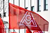 Rote IG Metall Fahne vor einem Industriegebäude als Symbolbild für die Tarifrunde 2026 in der Metall und Elektroindustrie, die Kündigung der Entgelttarifverträge durch die IG Metall, bevorstehende Tarifverhandlungen für rund 3,8 Millionen Beschäftigte, Forderungen nach höheren Entgelten, Kaufkraftsicherung und Beschäftigungssicherung sowie die angespannte wirtschaftliche Lage der M+E Industrie mit Rezession, schwacher Nachfrage, hohen Standortkosten und Strukturkrise in Deutschland.