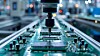Automatischer Fertigungsarm über einer Leiterplatte in einer Elektronikfabrik.