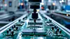 Automatischer Fertigungsarm über einer Leiterplatte in einer Elektronikfabrik.