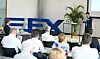 Redner vor Publikum in einem Konferenzraum neben großem FXE-Logo.