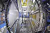 Blick in den geöffneten ATLAS-Detektor am CERN in der Schweiz mit großen ringförmigen Detektorstrukturen, massiven Modulen, Kabeln, Leitungen, Trägerrahmen, Arbeitsplattformen und technischer Infrastruktur in einer unterirdischen Experimentierhalle. Der ATLAS-Detektor gehört zu den wichtigsten Detektoren am Large Hadron Collider und untersucht Teilchen, die bei Frontalkollisionen von Protonen entstehen. Die aufgenommenen Messdaten helfen Forschenden unter anderem bei Studien zum Higgs-Boson, zu möglichen neuen Teilchen, zur dunklen Materie, zur Vereinheitlichung fundamentaler Kräfte und zu Physik jenseits des Standardmodells. Das Bild verdeutlicht die enorme technische Komplexität des Detektors: Sensoren, Ausleseelektronik, Stromversorgung, Kühlung, Datenübertragung und mechanische Strukturen müssen auf engem Raum zusammenarbeiten. Im Zuge des Umbaus zum High-Luminosity LHC wird ATLAS für deutlich höhere Kollisionsraten vorbereitet. Dazu gehören neue Silizium-Tracking-Systeme, Milliarden Auslesekanäle, strahlenharte Readout-Chips, präzisere Zeitmessung sowie leistungsfähigere Trigger- und Datenerfassungssysteme, die aus einer extrem hohen Zahl von Teilchenkollisionen die wissenschaftlich relevanten Ereignisse auswählen.