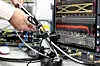 Technikerhand an einem Prüfadapter vor einem Oszilloskop mit angeschlossenen Hochfrequenzkabeln und Messleitungen im BitifEye-Testlabor. Der Aufbau dient der Validierung digitaler Hochgeschwindigkeitsschnittstellen auf der physikalischen Schicht und veranschaulicht Compliance-Testing für SerDes-Verbindungen, MIPI A-PHY, PCIe und weitere Standards, die in ADAS-Systemen, Zentralrechnern und softwaredefinierten Fahrzeugarchitekturen zum Einsatz kommen.
