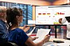 Personen in einem Meeting betrachten an einem Monitor Finanzgrafiken und Diagramme.