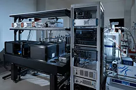 Prototyp des Diamant-Spin-Quantencomputers von Fujitsu im Labor mit optischem Aufbau, elektronischen Steuergeräten, Messsystemen und kryogener Kühltechnik für Diamant-Qubits.