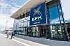 Gläserner Messeeingang mit großem EFX-Banner und wenigen Besuchern vor dem Gebäude.