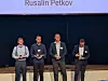 Vier Männer mit Auszeichnungen auf einer Bühne unter einer Anzeige mit dem Namen Rusalin Petkov.