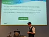 Ein Mann hält einen Vortrag vor einer Folie über KI-Standards.
