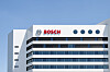 Bosch-Logo auf der Fassade eines modernen Bürogebäudes vor blauem Himmel.