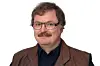 Porträt von Andreas Zeiff vom Redaktionsbüro Stutensee vor weißem Hintergrund. Er trägt eine rechteckige Brille mit dunklem Gestell, einen Schnurrbart sowie eine braune Lederweste über einem dunklen Hemd. Sein braunes Haar ist mittellang und leicht gewellt.