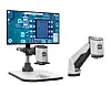 Freigestellte Anordnung des digitalen Mikroskops EVO Cam AURA von Vision Engineering auf hellem Hintergrund: ein Monitor mit stark vergrößerter Ansicht einer elektronischen Leiterplatte, eine kompakte Kameraeinheit auf einem Tischfuß und eine Kamera an einem beweglichen Haltearm.