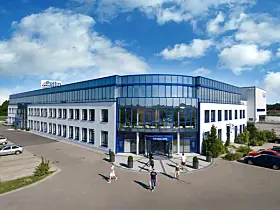 Außenansicht des Pollin Electronic Centers in Pförring mit weißer Gebäudefassade, einer großen blau gerahmten Glasfront am Haupteingang und dem Schriftzug „Electronic Center“.