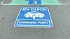 A sign for an EV quick charger on the floor of a rooftop parking lot at an AEON Shopping Mall