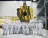 Reinraumarbeiter posieren 2016 für ein Gruppenfoto mit den Spiegeln des James-Webb-Weltraumteleskops. In den Spiegeln ist das NASA-Logo zu sehen.