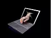 Hand greift durch Laptop