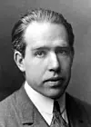 Niels Bohr (1885–1962) Berühmt für: Atommodell und Quantenmechanik Bohr entwickelte das Bohrsche Atommodell, das erklärte, wie Elektronen stabile Bahnen um den Atomkern ziehen, ohne dabei Energie zu verlieren, und dass Elektronen bei einem Sprung zwischen Bahnen Energie in Form von Licht abgeben oder aufnehmen. Dieses Modell war ein erster Schritt zur modernen Quantenmechanik. Bohr spielte auch eine zentrale Rolle in der Entwicklung der Kernphysik und des Verständnisses von Quantenzuständen.