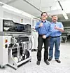 Geschäftsführer Alfred Hutt und Fertigungsleiter Thomas Ludwig entdecken die E by Siplace auf der SMT Hybrid Packaging 2015.