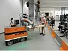 Kuka erforscht psychosoziale Aspekte der Mensch-Roboter-Kollaboration anhand eines Experiments, bei dem Roboter und Mensch gemeinsam einen Tisch tragen.