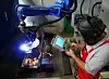 Schweisser bedient Roboter