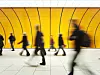 People blurry in motion in yellow tunnel down hallway