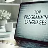 Eine professionelle Umgebung mit einem Laptop auf einem sauberen, modernen Schreibtisch. Auf dem Bildschirm des Laptops erscheinen die Worte „Top Programming Languages“